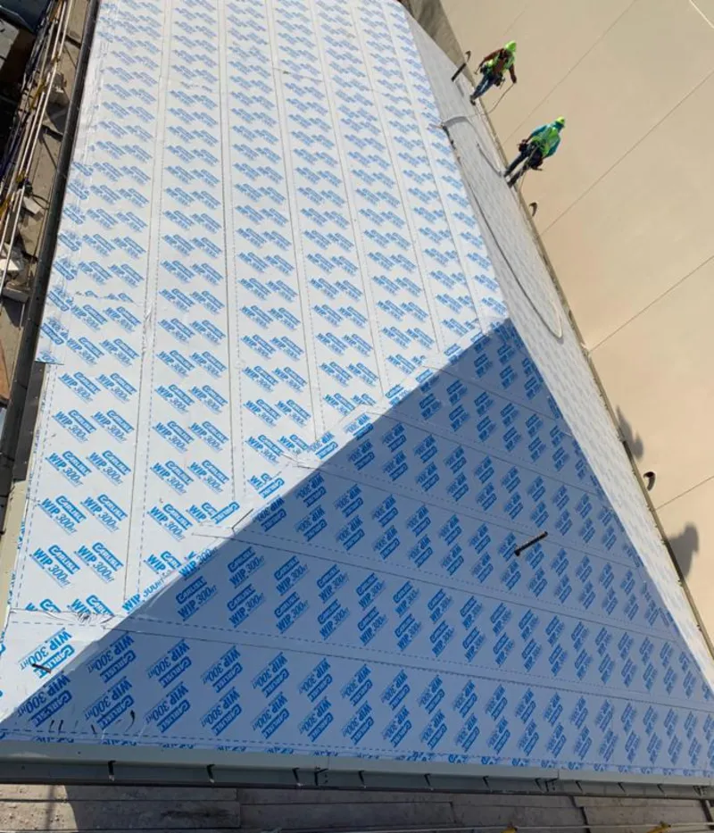 Professional roofers installing underlayment on a metal roof in Nappanee